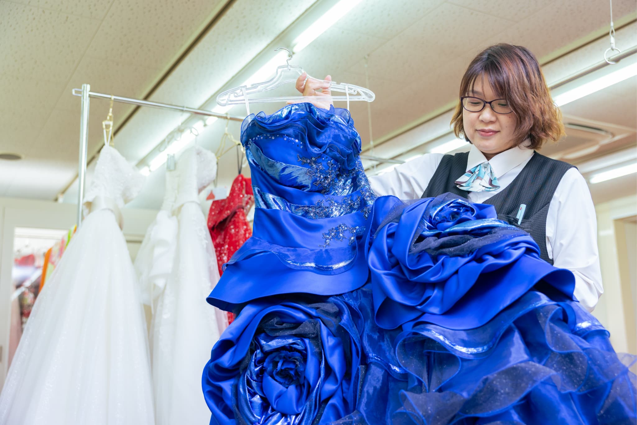 ドレスを見つめる女性社員の写真