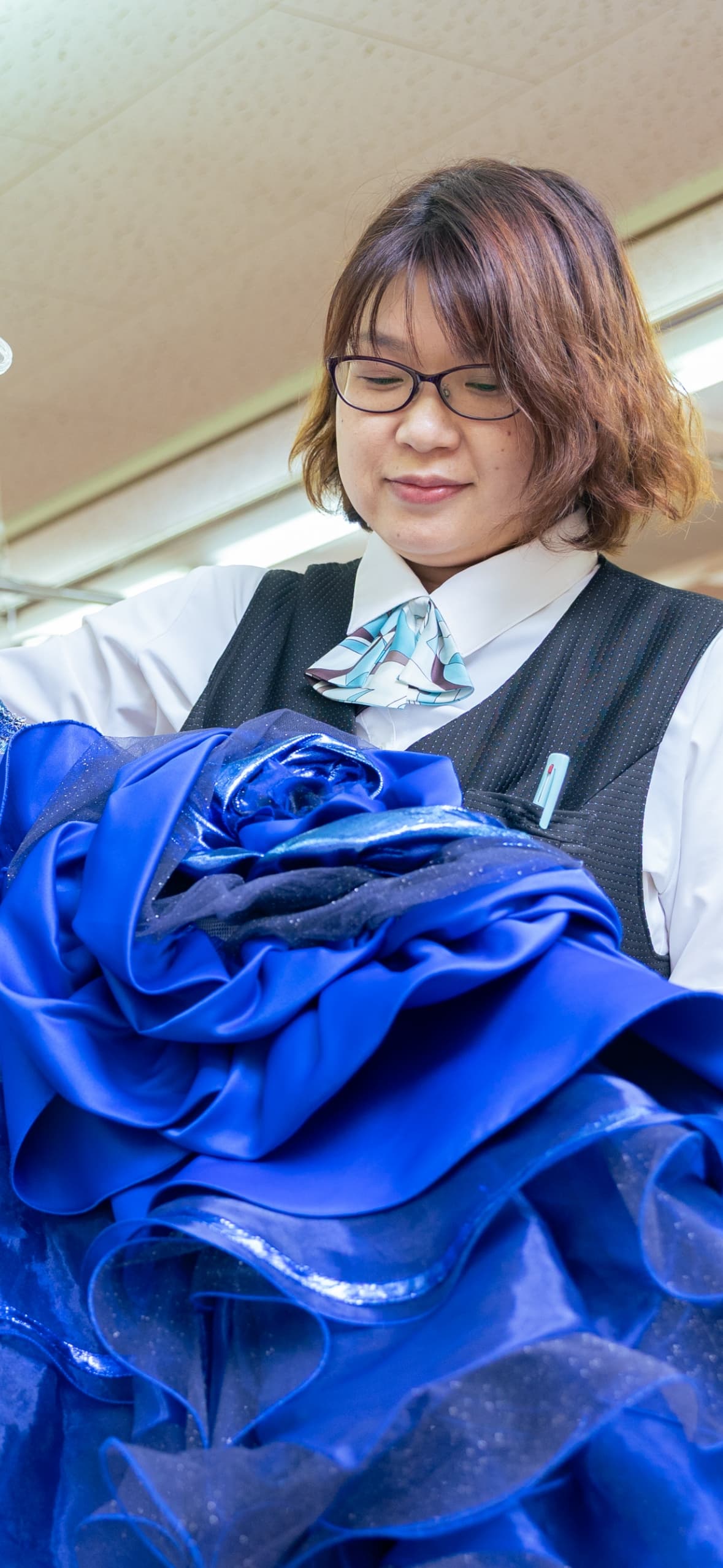 ドレスを見つめる女性社員の写真