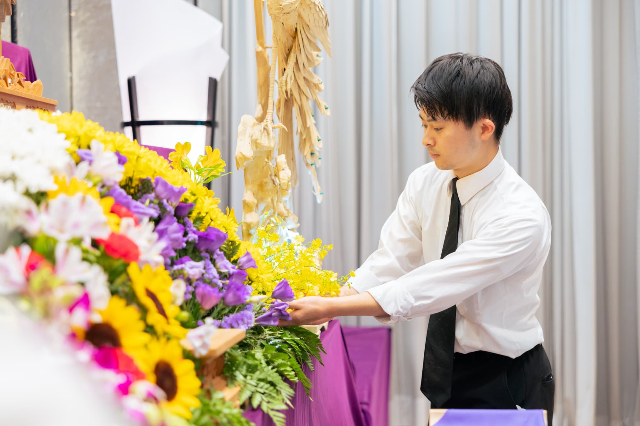花の位置を調整する男性社員の写真