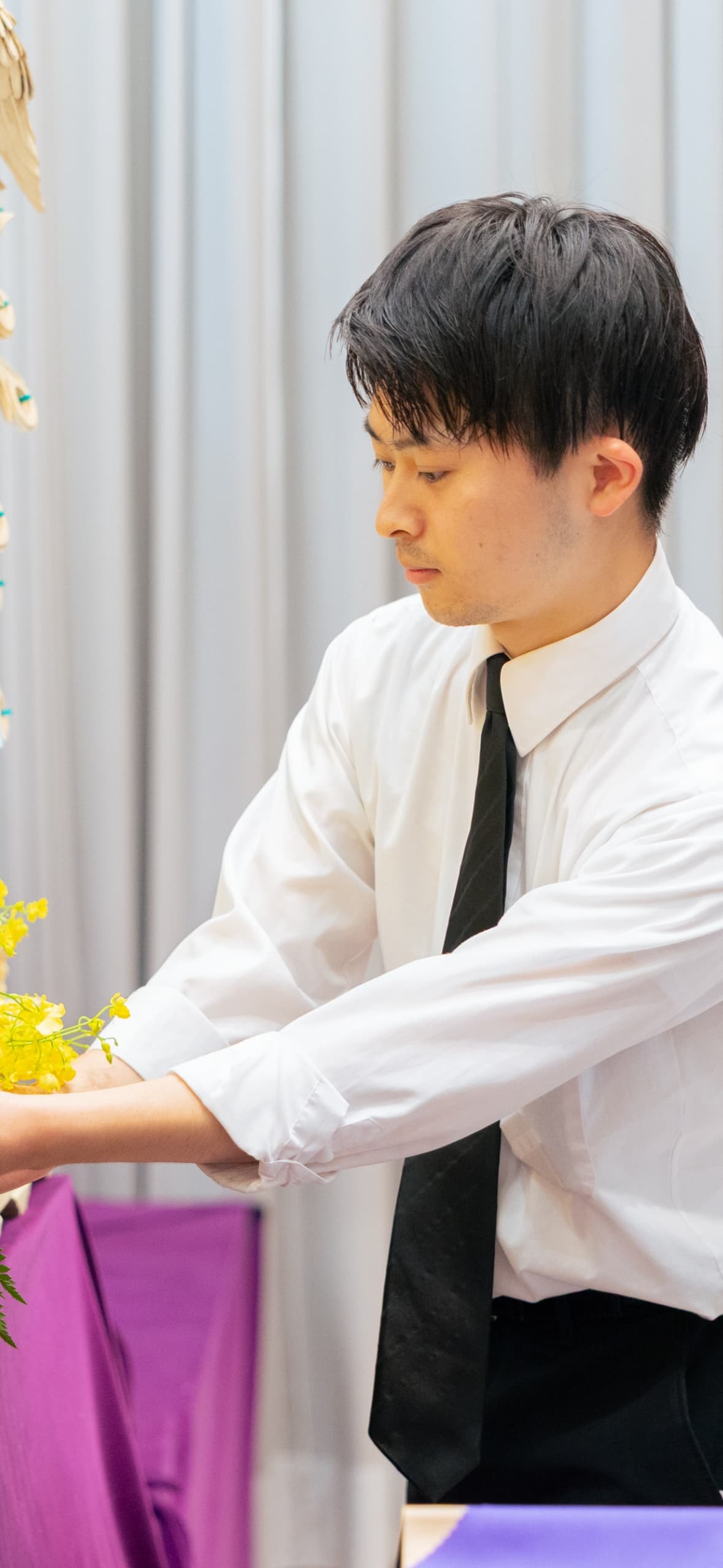 花の位置を調整する男性社員の写真